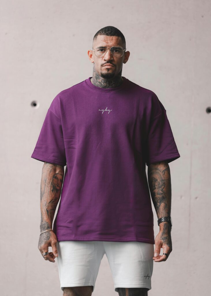Stylish man posing in a purple t-shirt and glasses indoors in Perth.