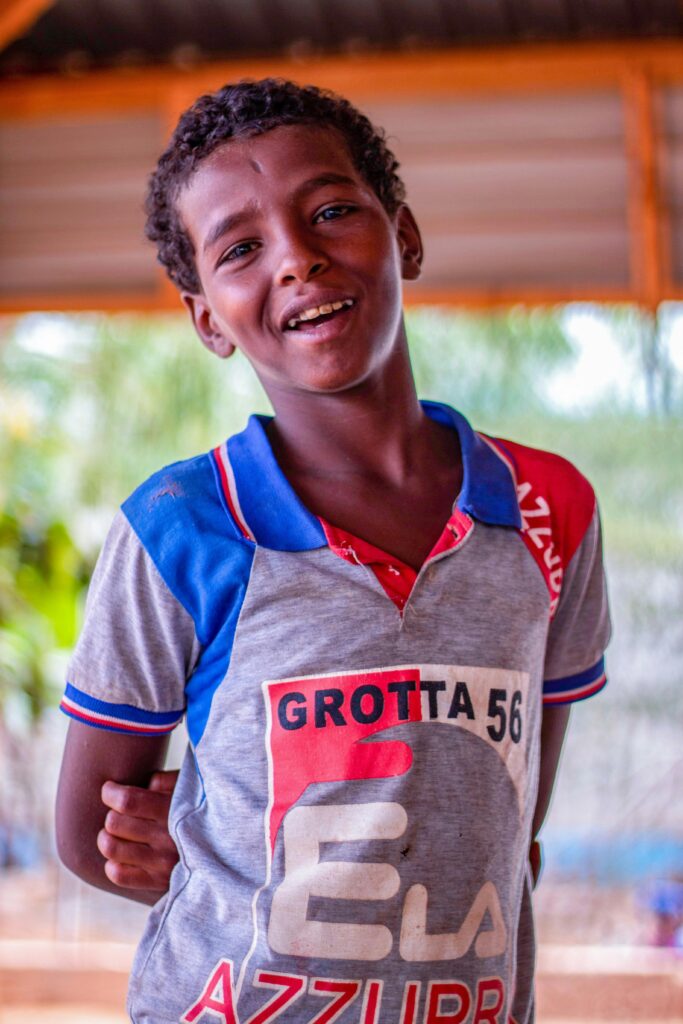 Smiling boy in a colorful shirt captured outdoors in Doolow, Gedo, Somalia.