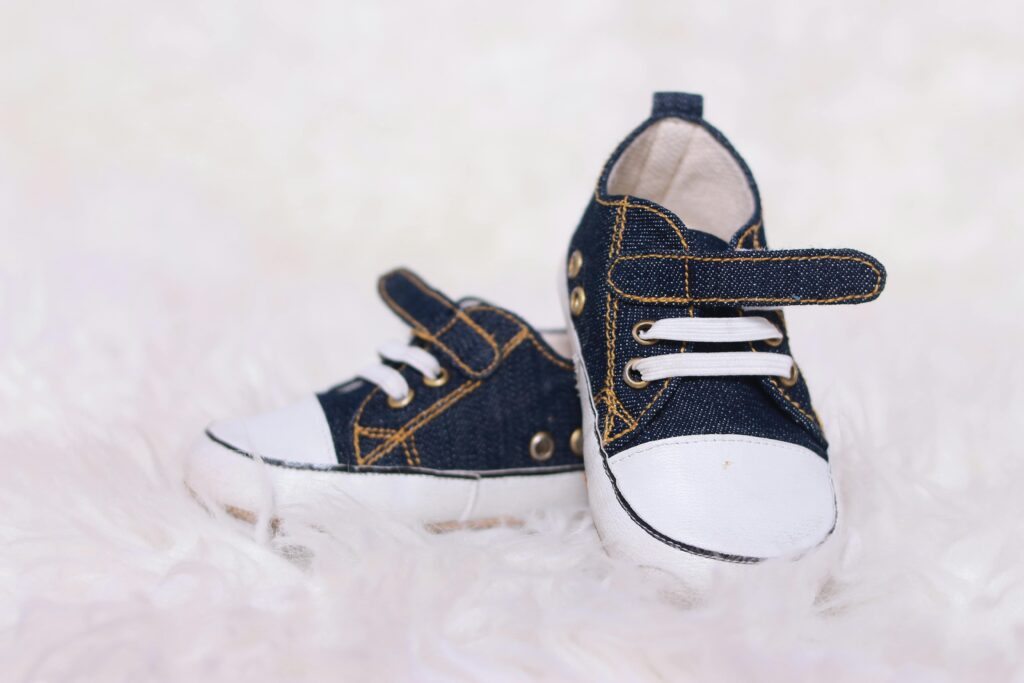 Close-up of cute denim baby sneakers on a soft white background, perfect for kids fashion.